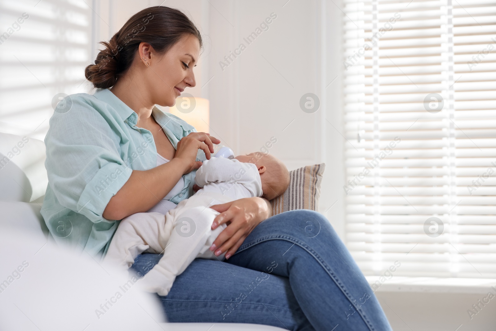 Photo of Mother feeding her cute baby at home