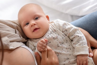 Photo of Mother with her cute little baby on bed at home, closeup