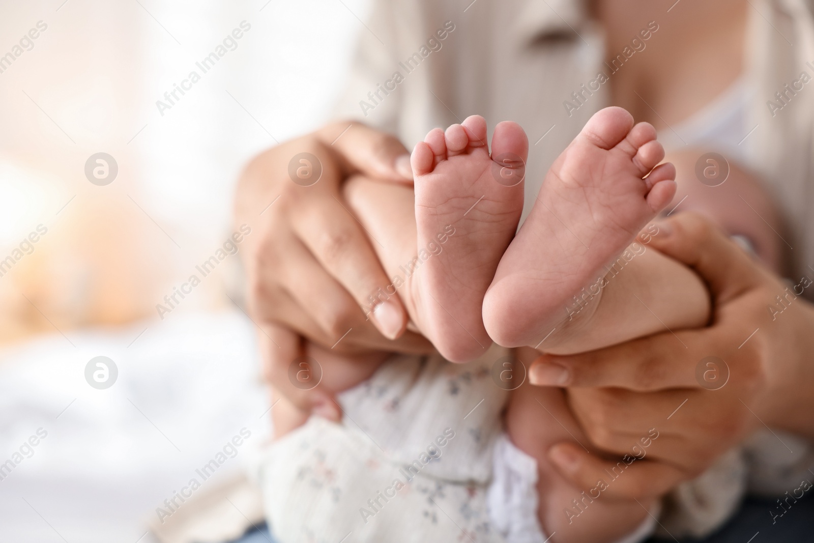 Photo of Mother with her cute little baby at home, closeup. Space for text