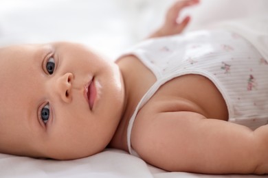 Photo of Cute little baby lying on bed at home