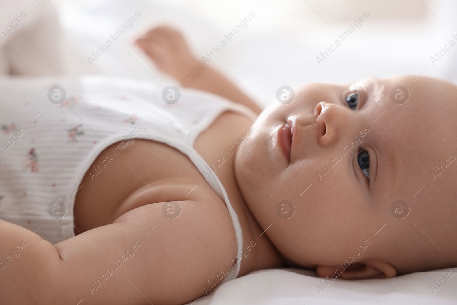 Photo of Cute little baby lying on bed at home