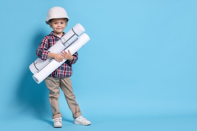 Photo of Little girl with house plan pretending to be architect on light blue background, space for text. Dreaming of future profession