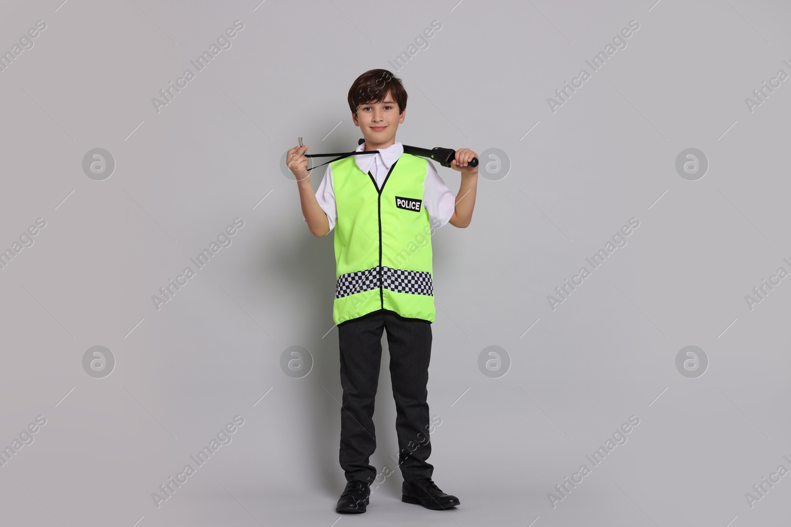 Photo of Boy pretending to be policeman on light grey background. Dreaming of future profession