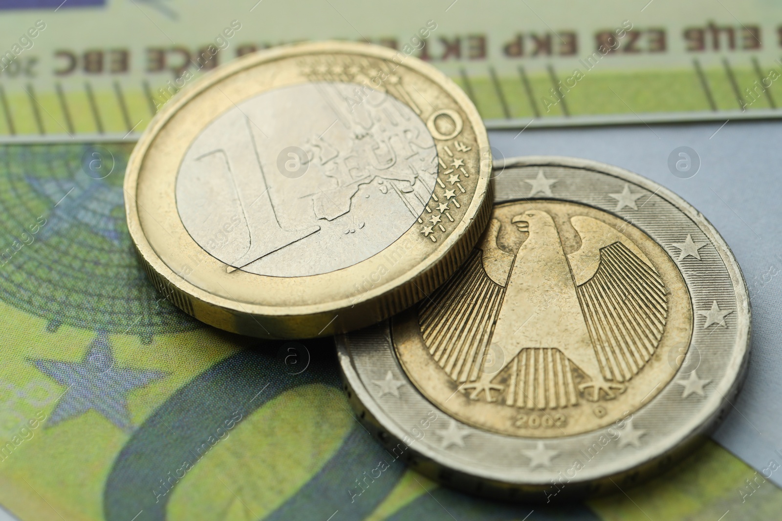 Photo of Different coins on euro banknotes, closeup view