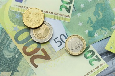 Photo of Different coins on euro banknotes, top view