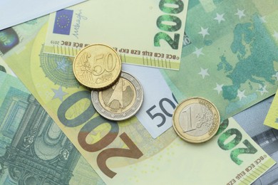 Photo of Different coins on euro banknotes, top view