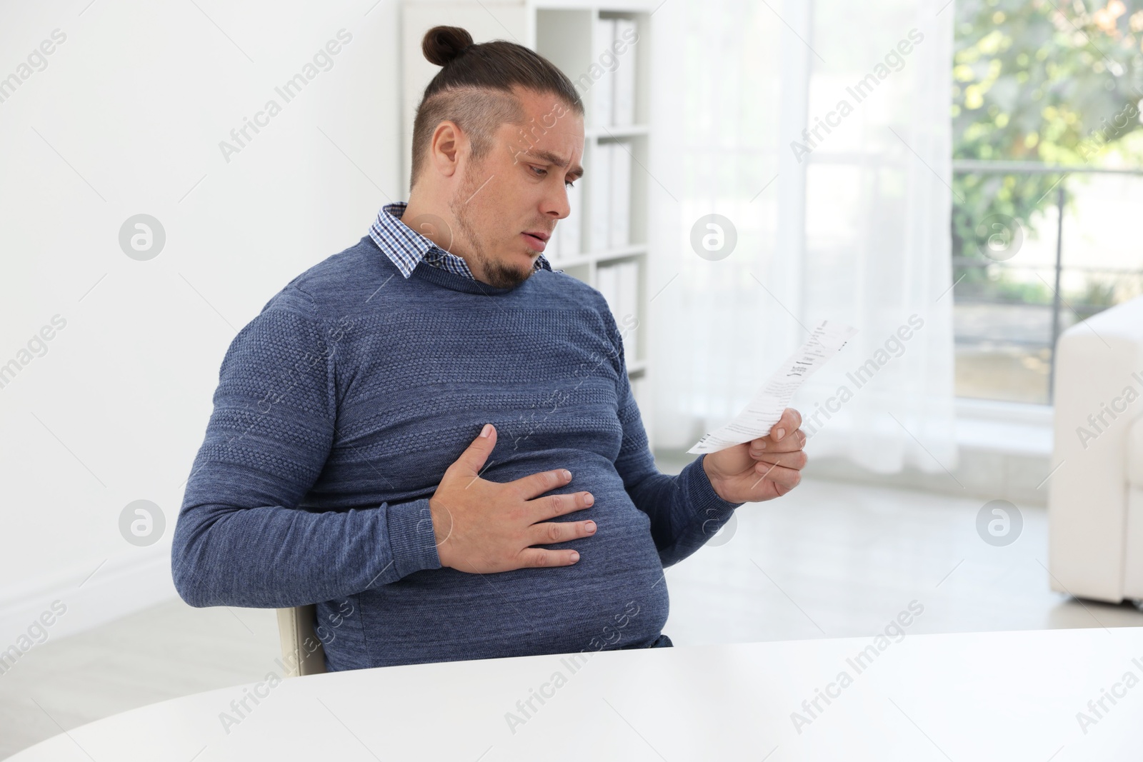 Photo of Overweight man with doctor's prescription in clinic