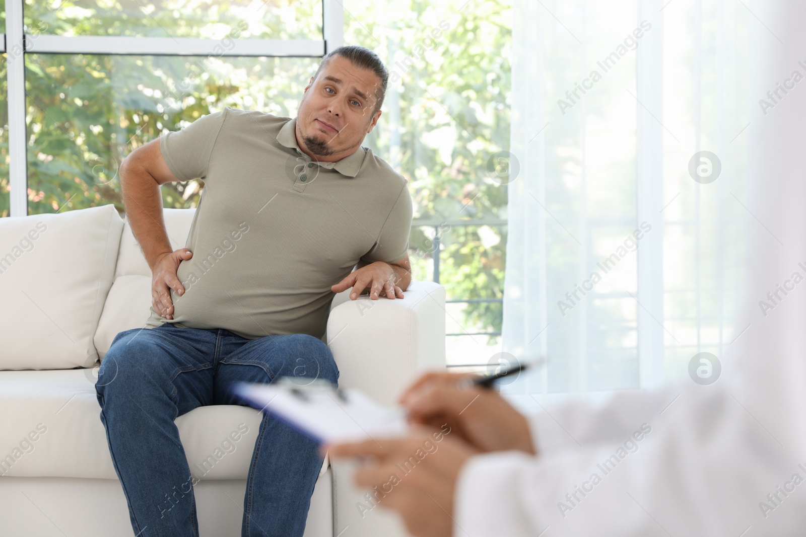 Photo of Overweight man having consultation with nutritionist in clinic, selective focus