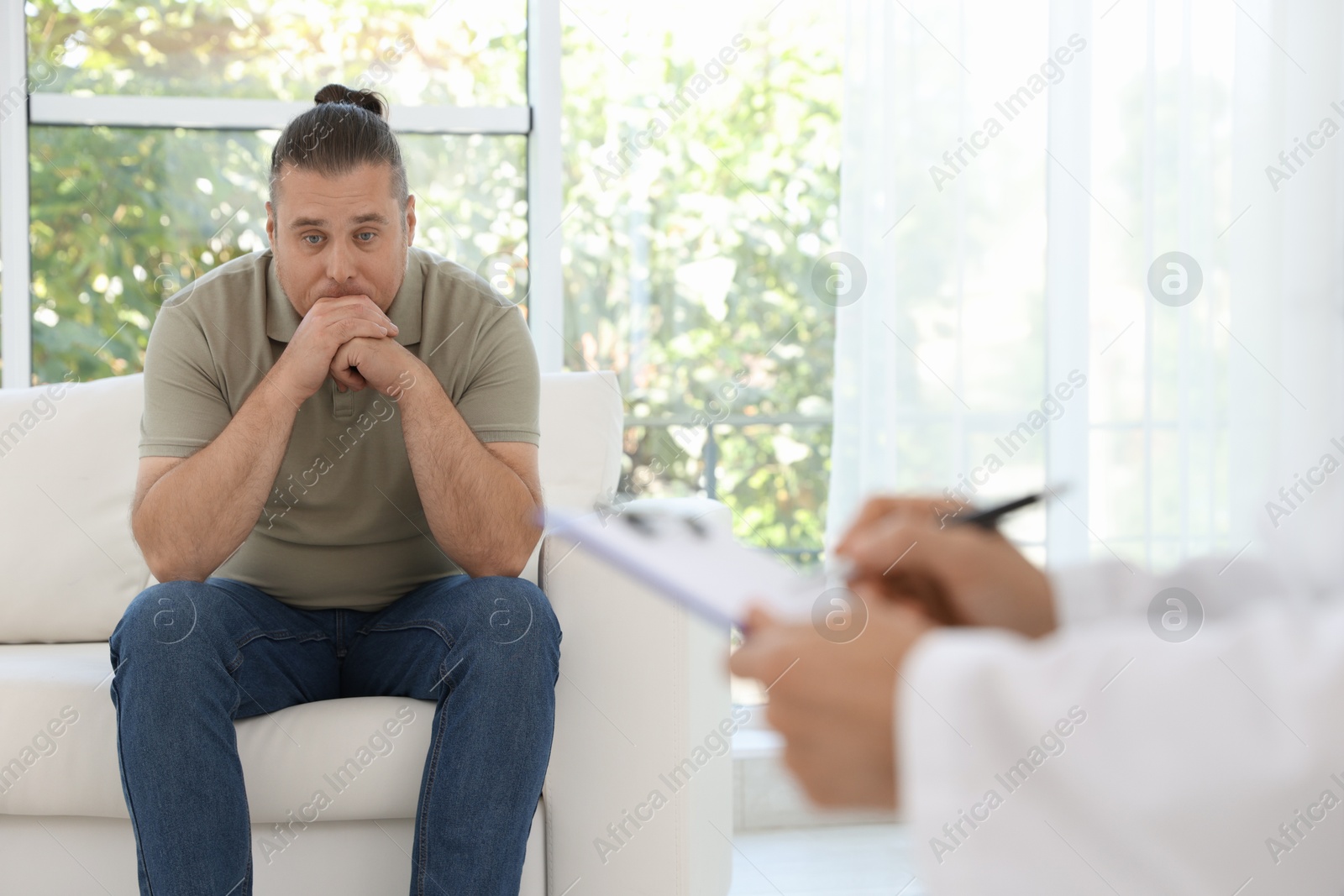 Photo of Overweight man having consultation with nutritionist in clinic, selective focus