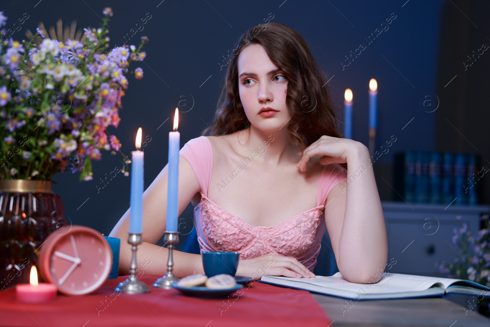 Photo of Beautiful young woman sitting at table in room. Fashion vintage style portrait