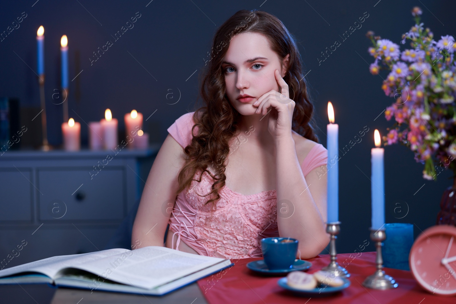 Photo of Beautiful young woman sitting at table in room. Fashion vintage style portrait