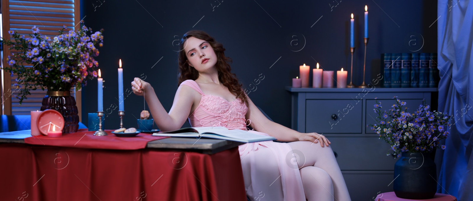 Photo of Beautiful young woman making tea at table in room. Fashion vintage style portrait