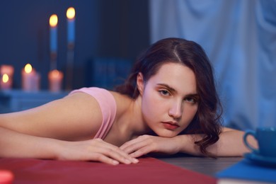 Photo of Beautiful young woman posing at table in room. Fashion vintage style portrait