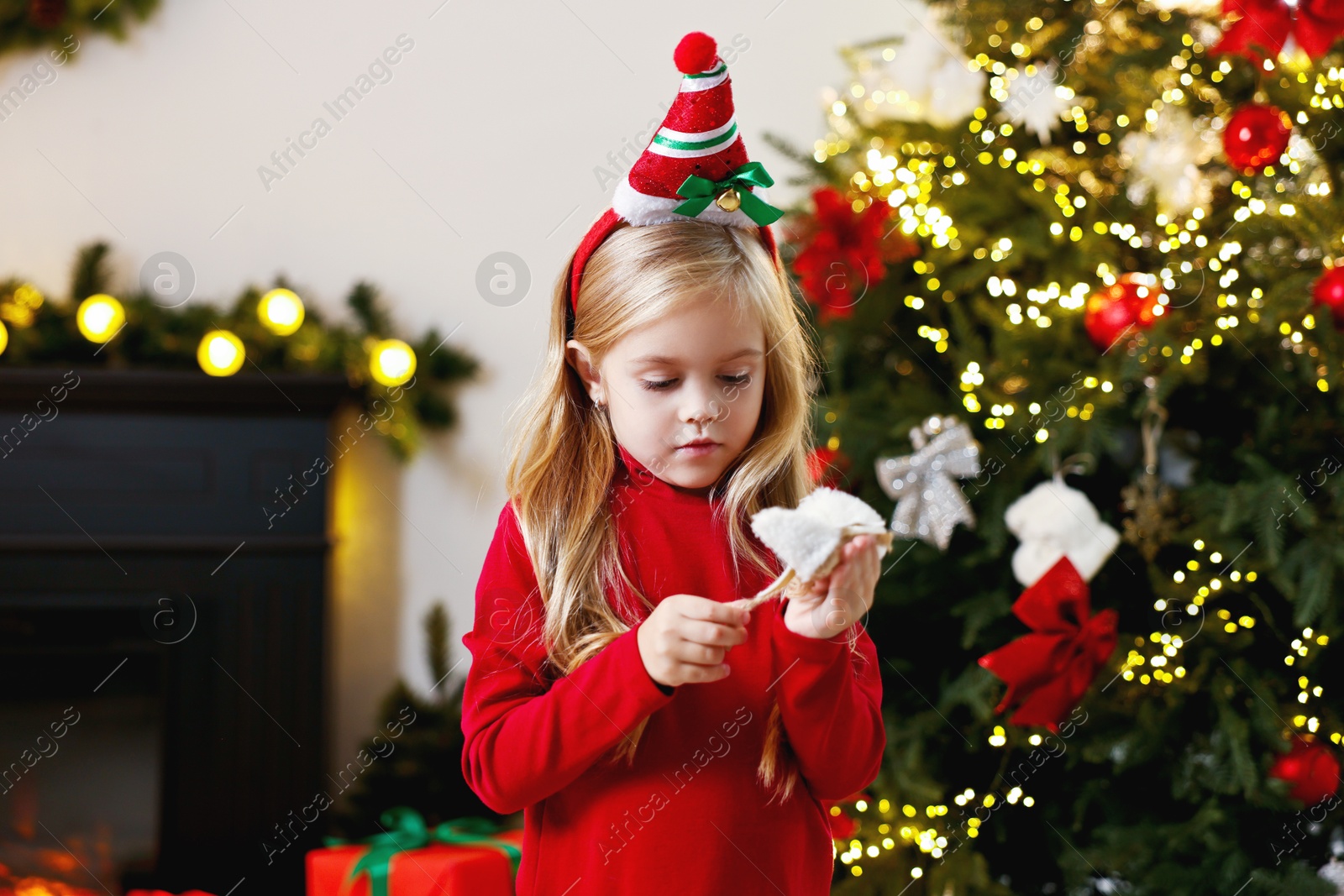 Photo of Little girl with Christmas ornament at home