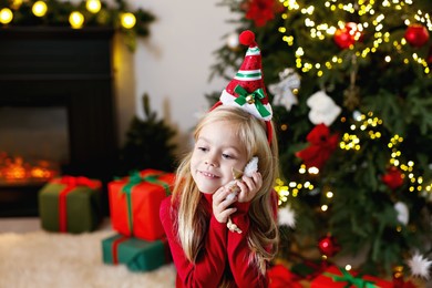 Photo of Little girl with Christmas ornament at home