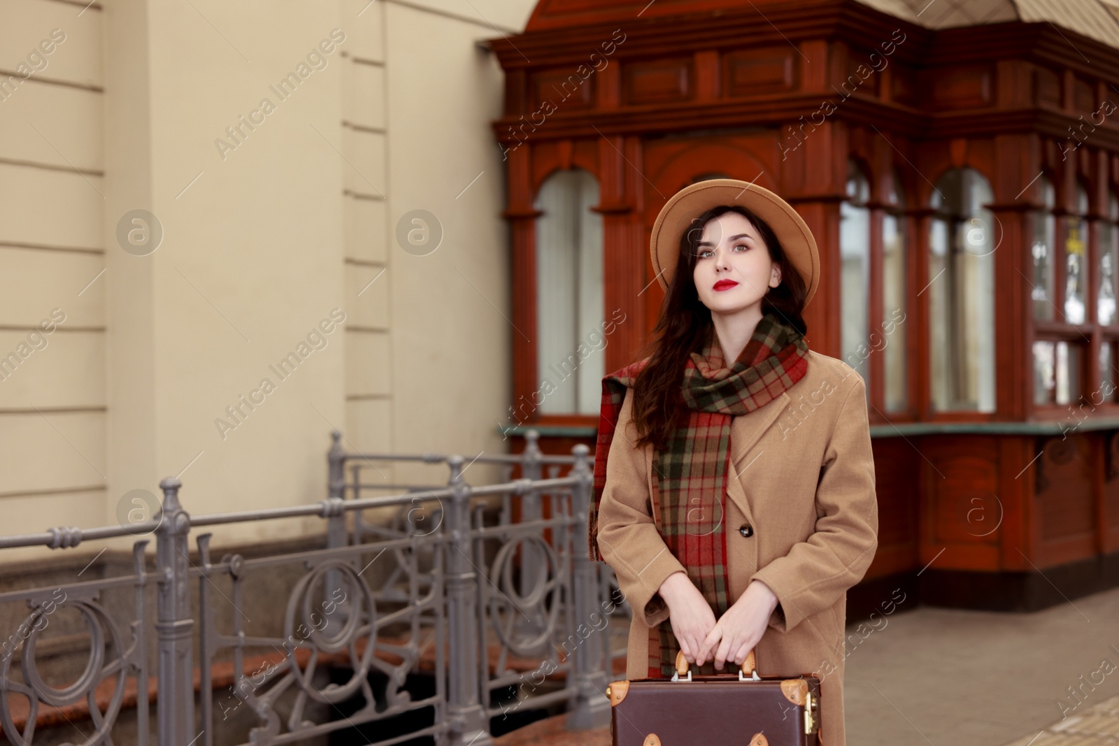 Photo of Beautiful woman with suitcase at railway station