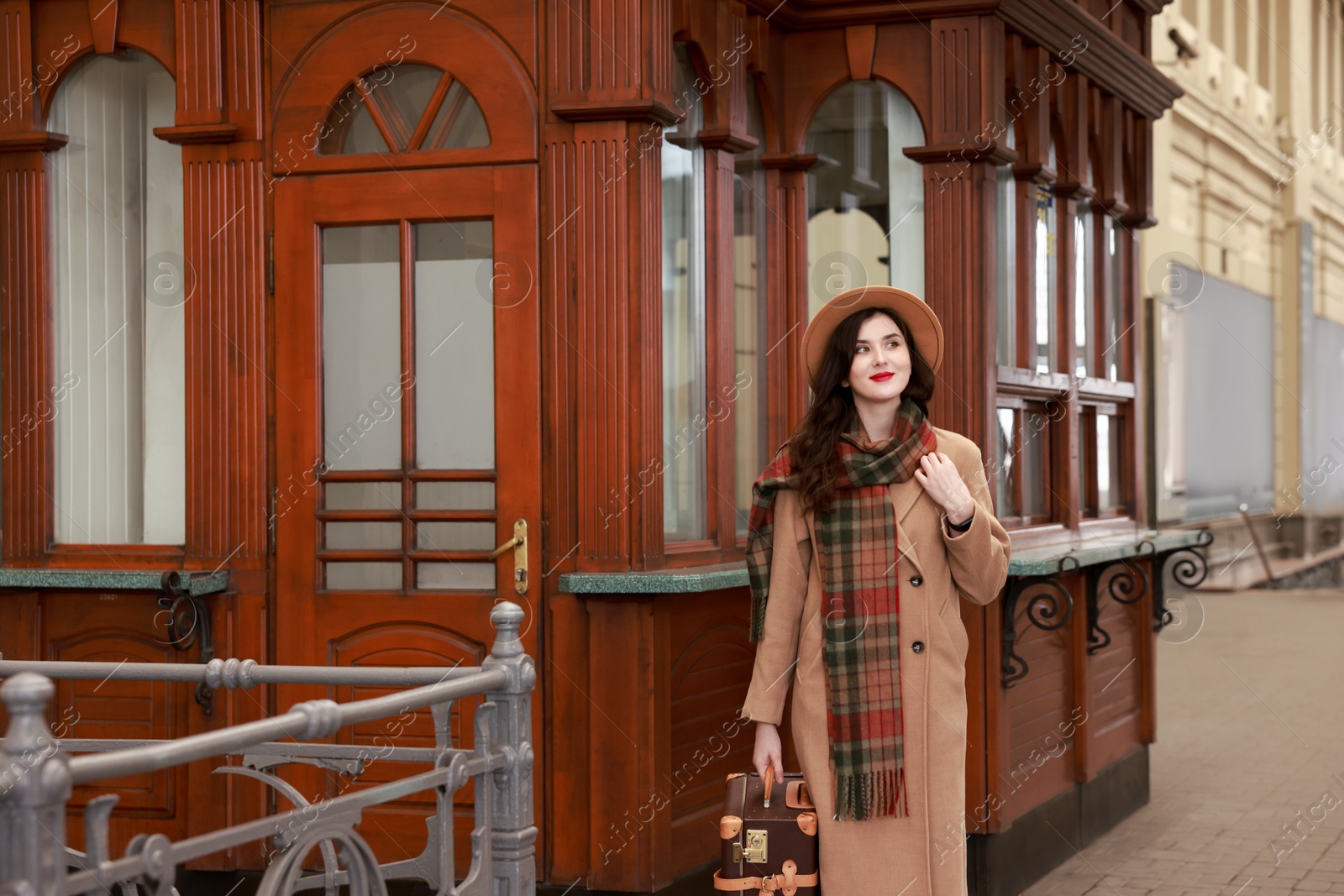 Photo of Beautiful woman with suitcase at railway station