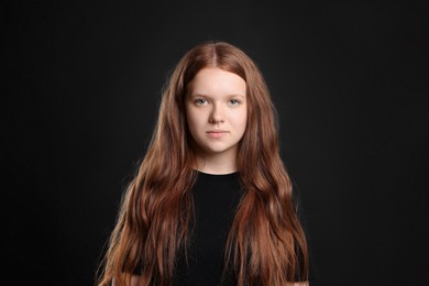 Photo of Pretty red-haired teenage girl on black background