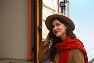 Photo of Woman with red scarf near train on platform of railway station