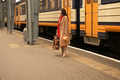 Photo of Woman with suitcase on platform of railway station