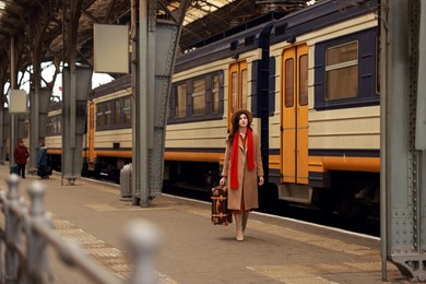 Photo of Woman with suitcase on platform of railway station