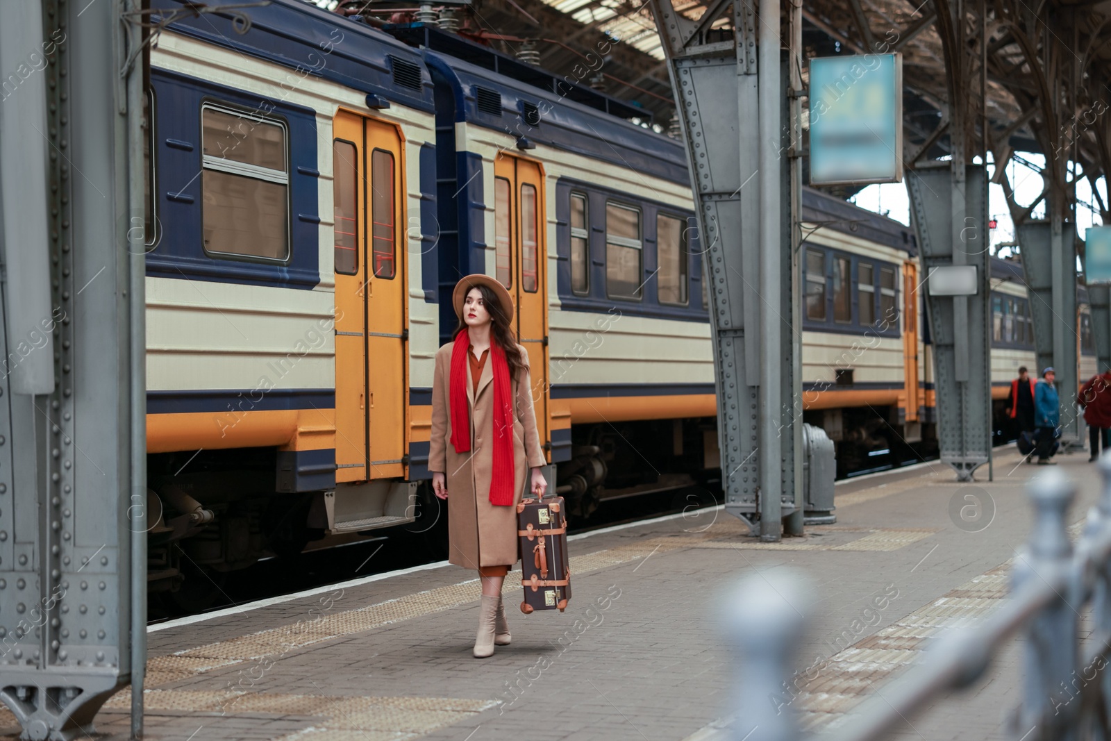 Photo of Woman with suitcase on platform of railway station