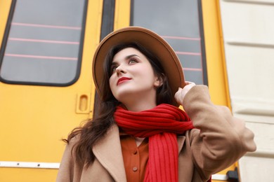 Photo of Beautiful woman with red scarf near train outdoors, low angle view