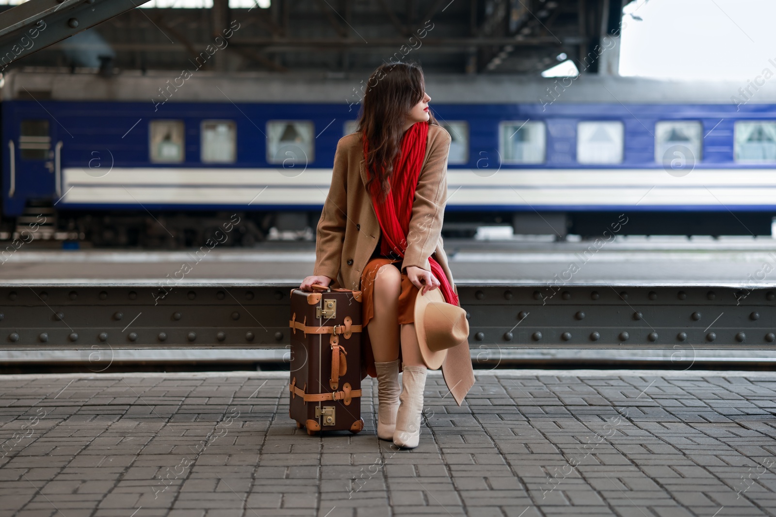 Photo of Woman with suitcase on platform of railway station