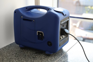 Photo of Modern portable power station on floor indoors