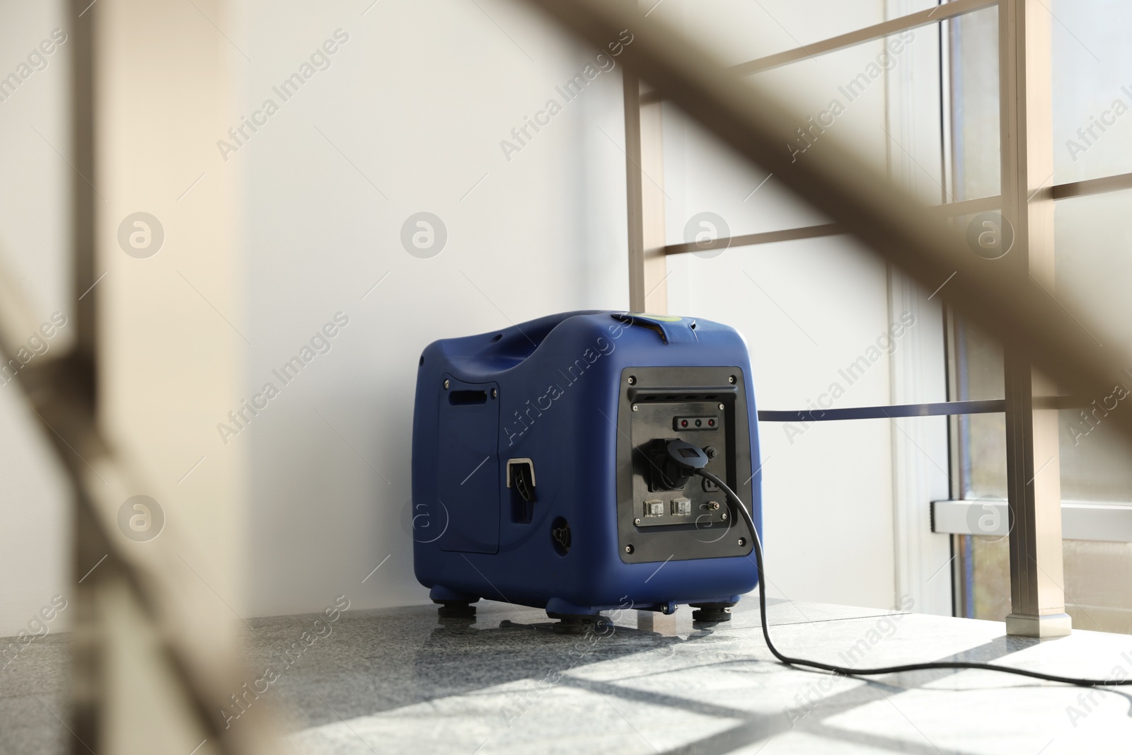 Photo of Modern portable power station on floor indoors