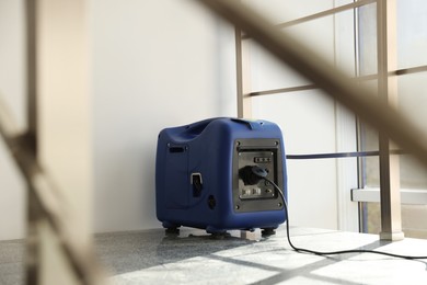 Photo of Modern portable power station on floor indoors