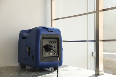 Photo of Modern portable power station on floor indoors