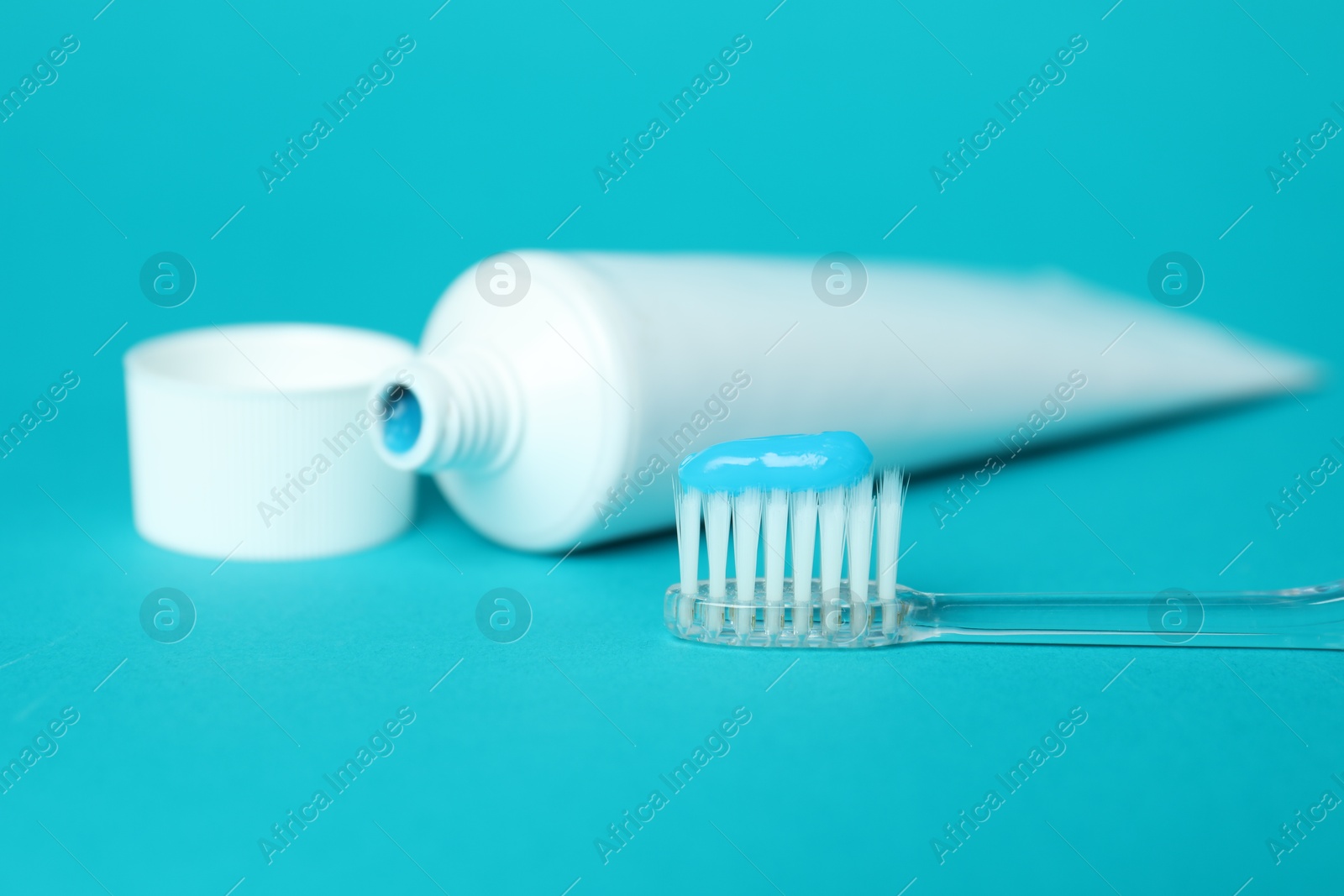 Photo of Toothbrush with toothpaste and tube on light blue background