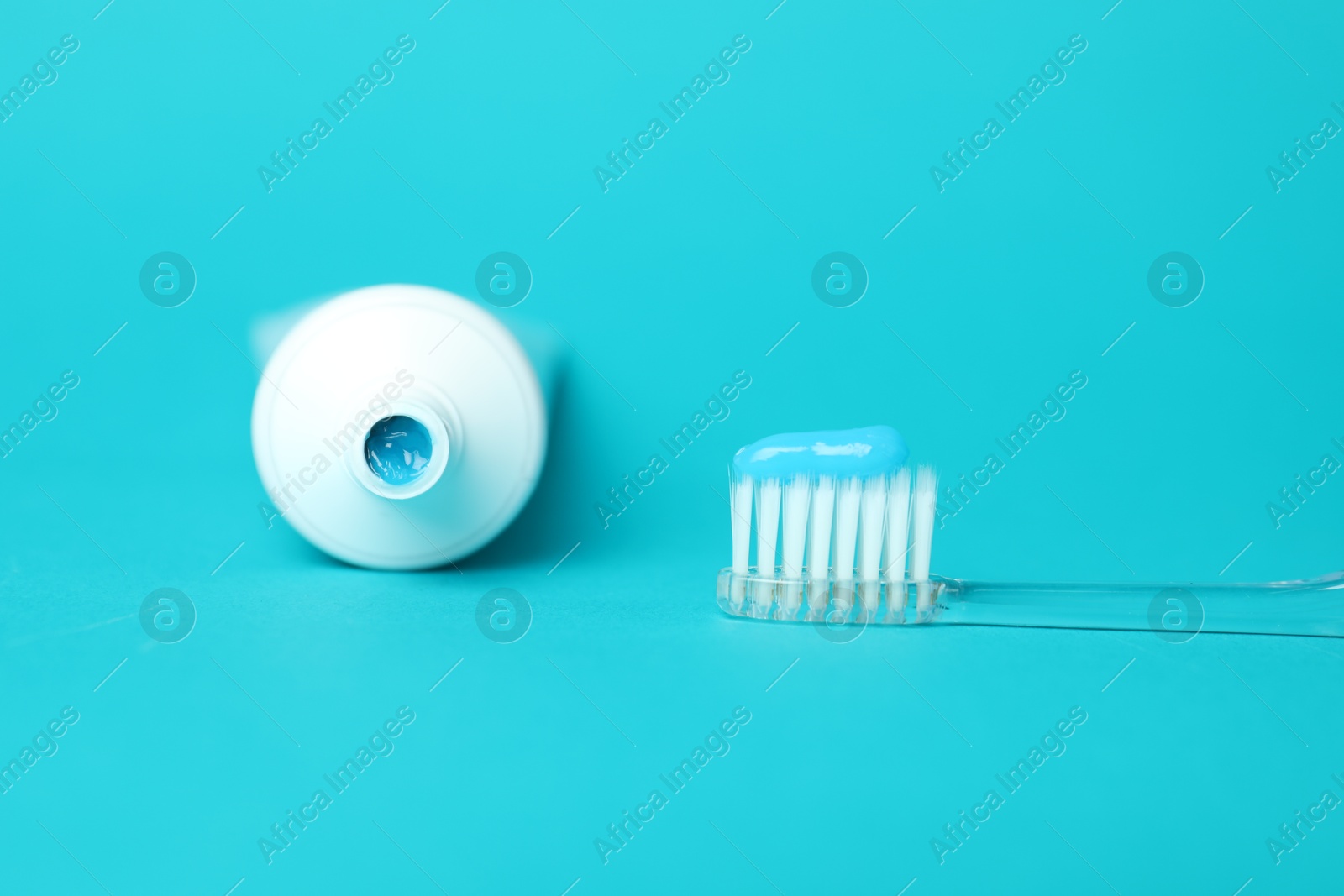 Photo of Toothbrush with toothpaste and tube on light blue background