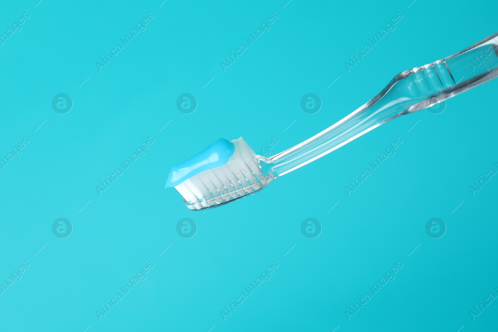 Toothbrush with toothpaste in air on light blue background, closeup. Space for text Photo of Toothbrush with toothpaste in air on light blue background, closeup. Space for text