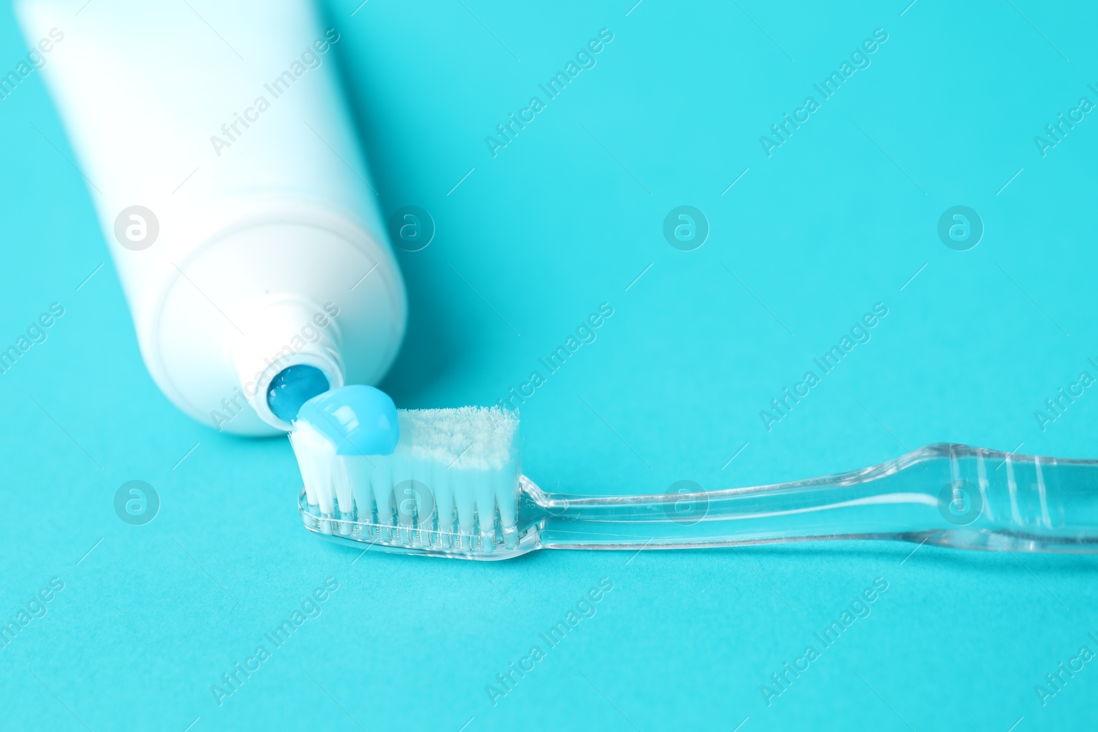 Photo of Toothbrush with toothpaste and tube on light blue background