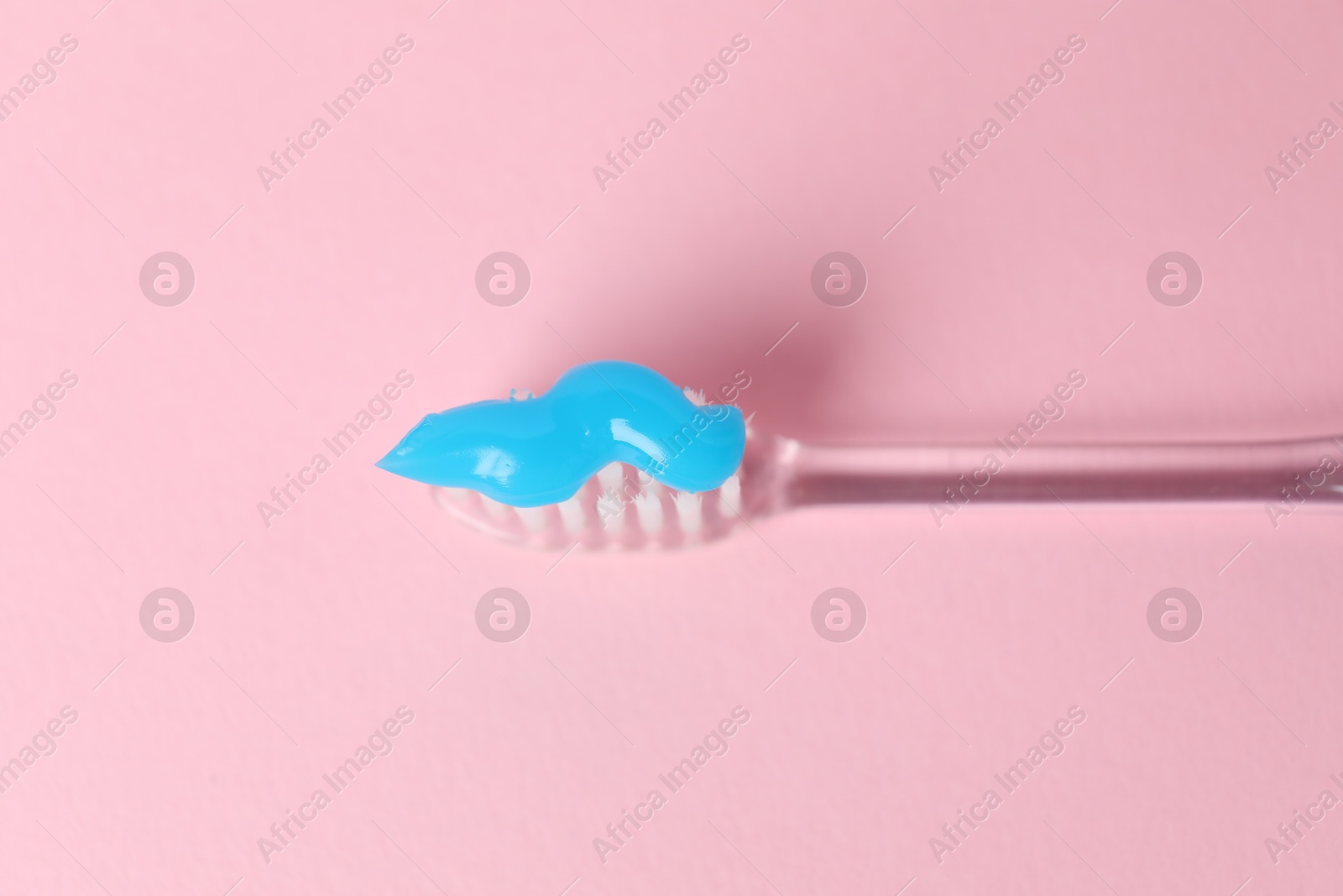 Toothbrush with toothpaste on pink background, top view Photo of Toothbrush with toothpaste on pink background, top view