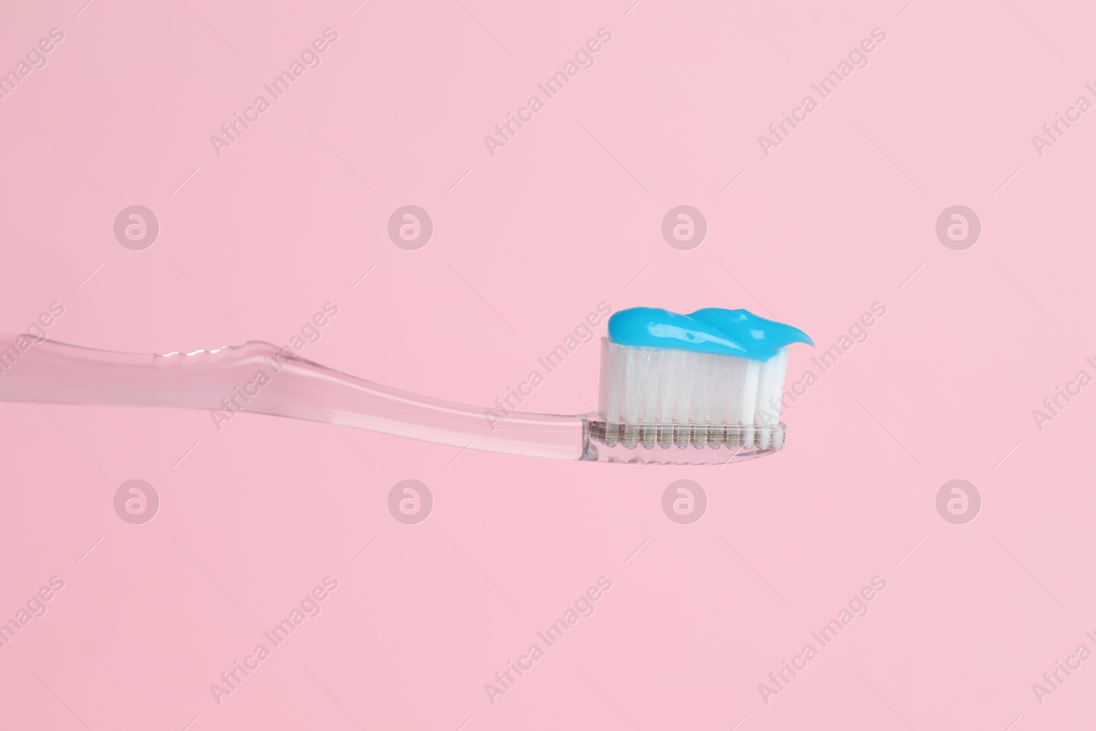 Toothbrush with toothpaste in air on pink background, closeup Photo of Toothbrush with toothpaste in air on pink background, closeup