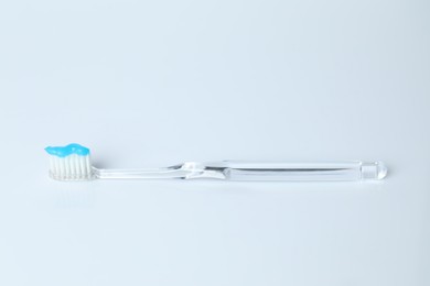 Photo of One toothbrush with toothpaste on white background