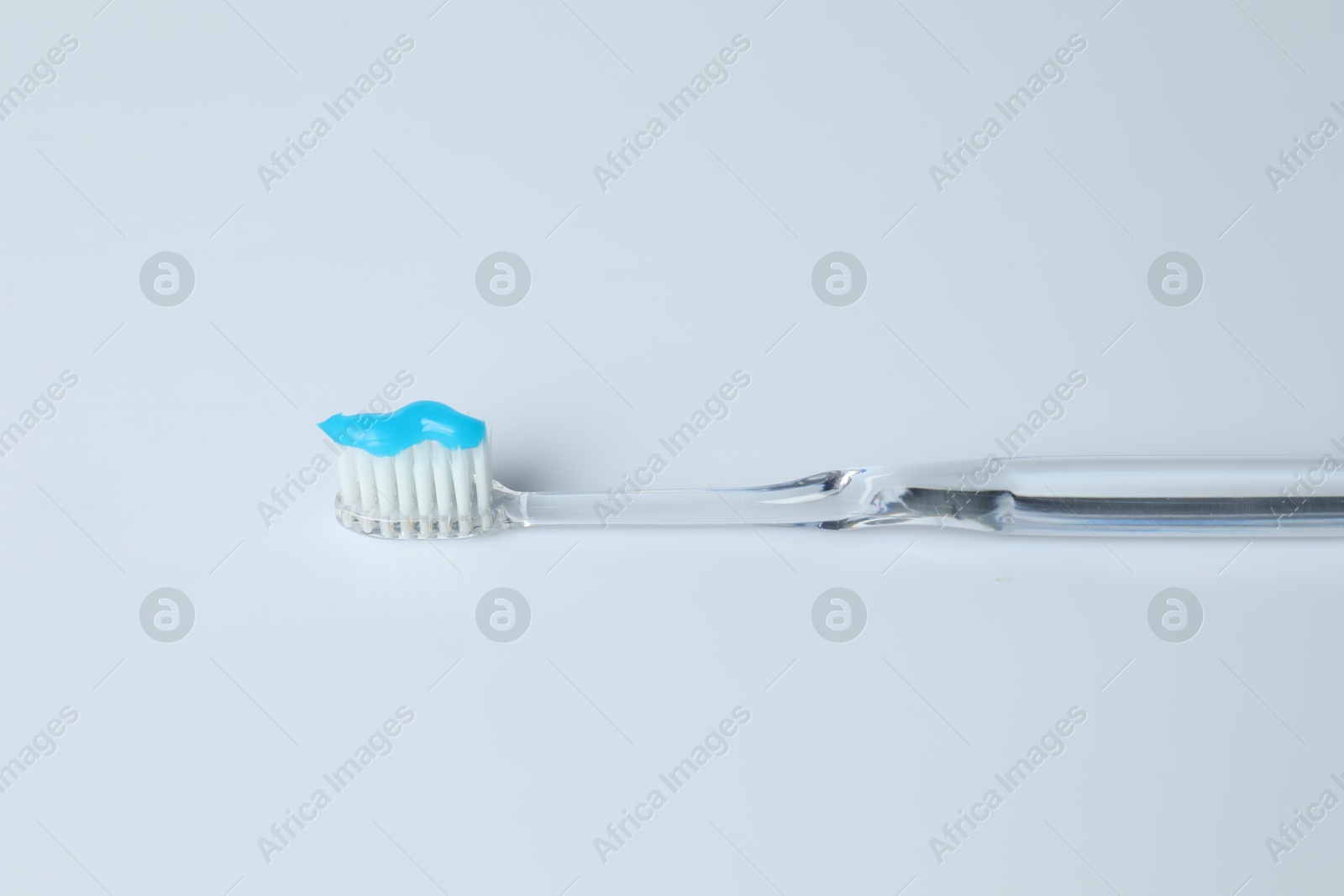 Photo of One toothbrush with toothpaste on white background