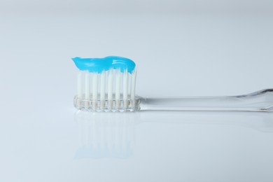 Photo of One toothbrush with toothpaste on white background, closeup