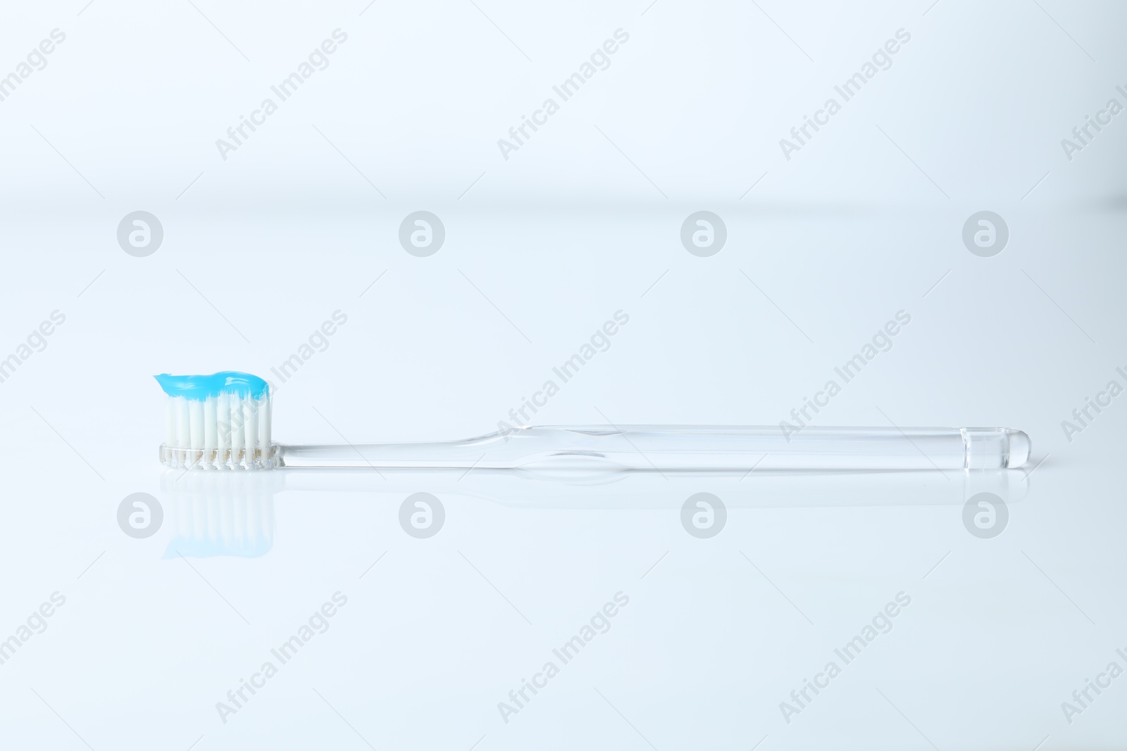 Photo of One toothbrush with toothpaste on white background