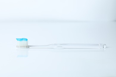 Photo of One toothbrush with toothpaste on white background