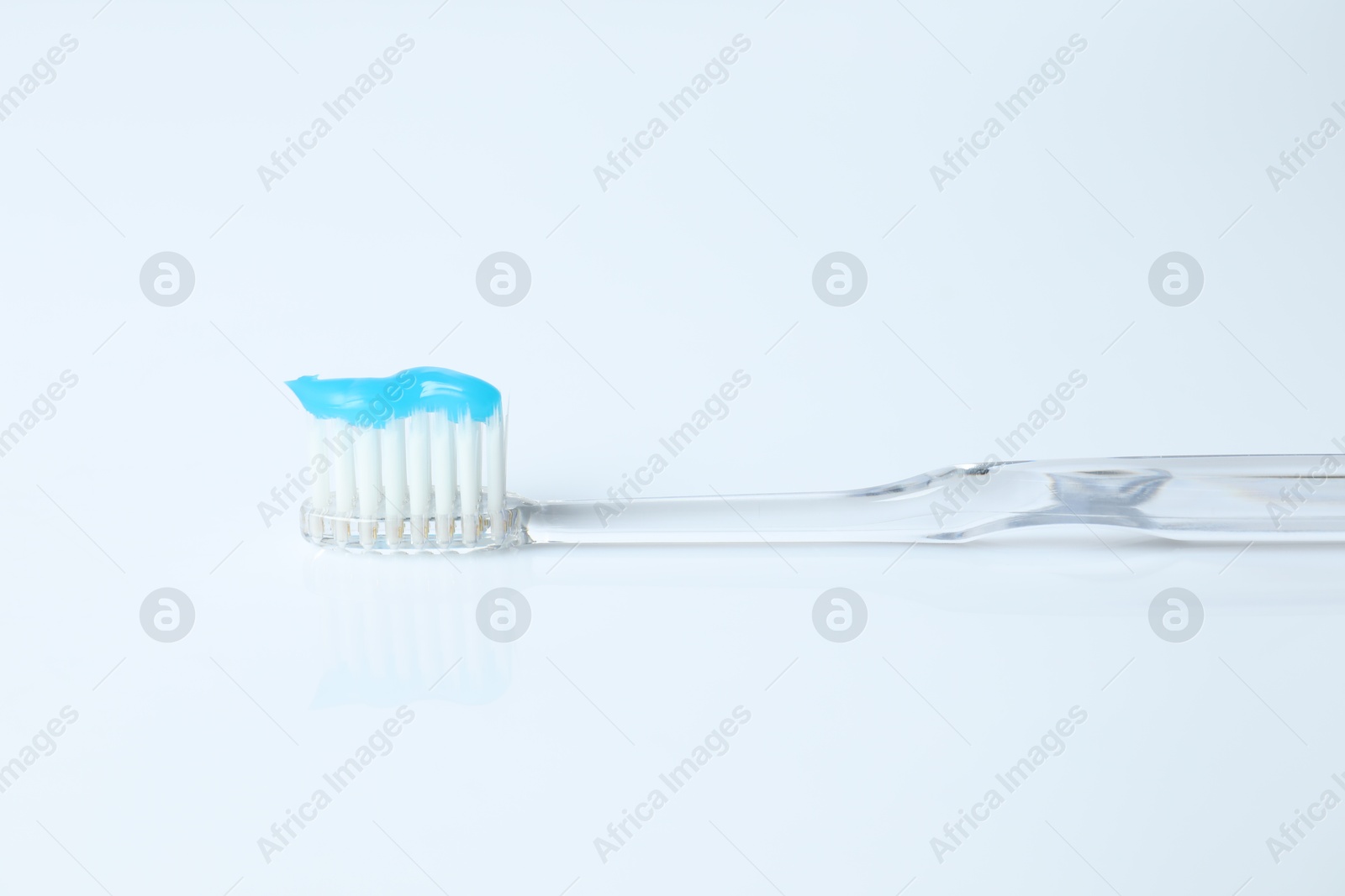 Photo of One toothbrush with toothpaste on white background