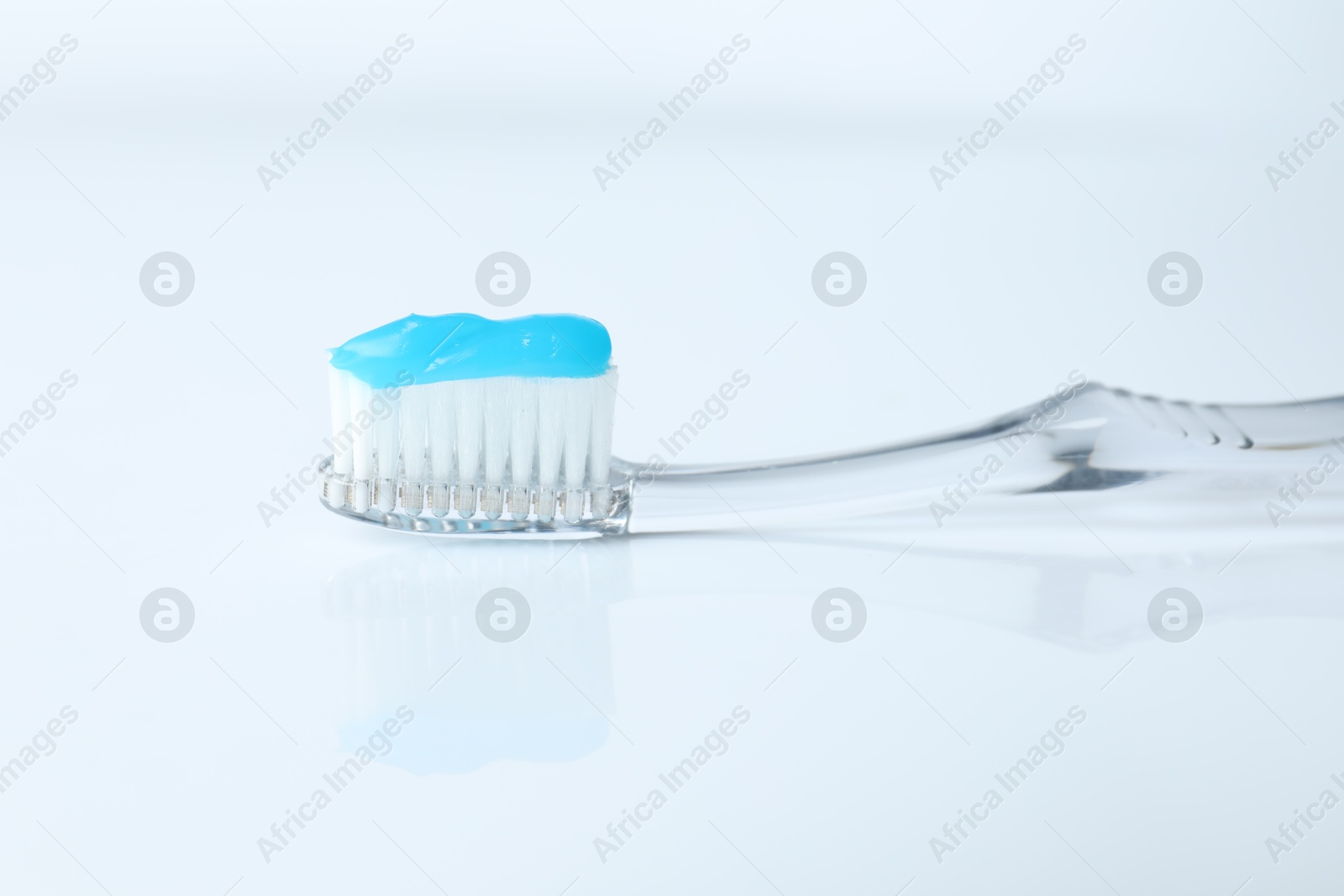 Photo of One toothbrush with toothpaste on white background