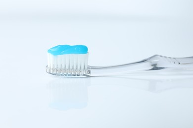 Photo of One toothbrush with toothpaste on white background