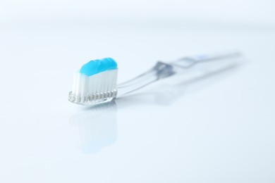 Photo of One toothbrush with toothpaste on white background