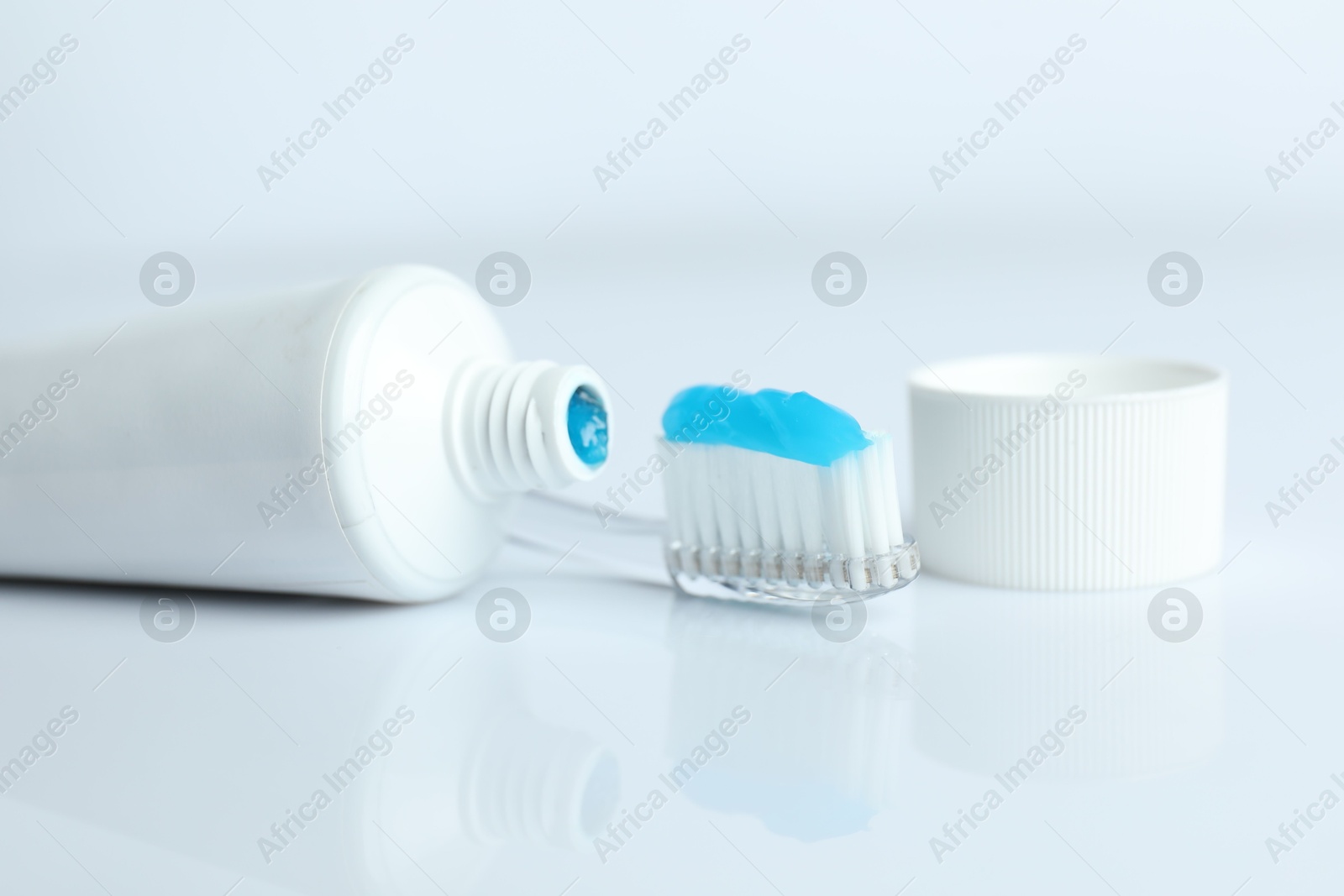 Photo of Toothbrush with toothpaste and tube on white background