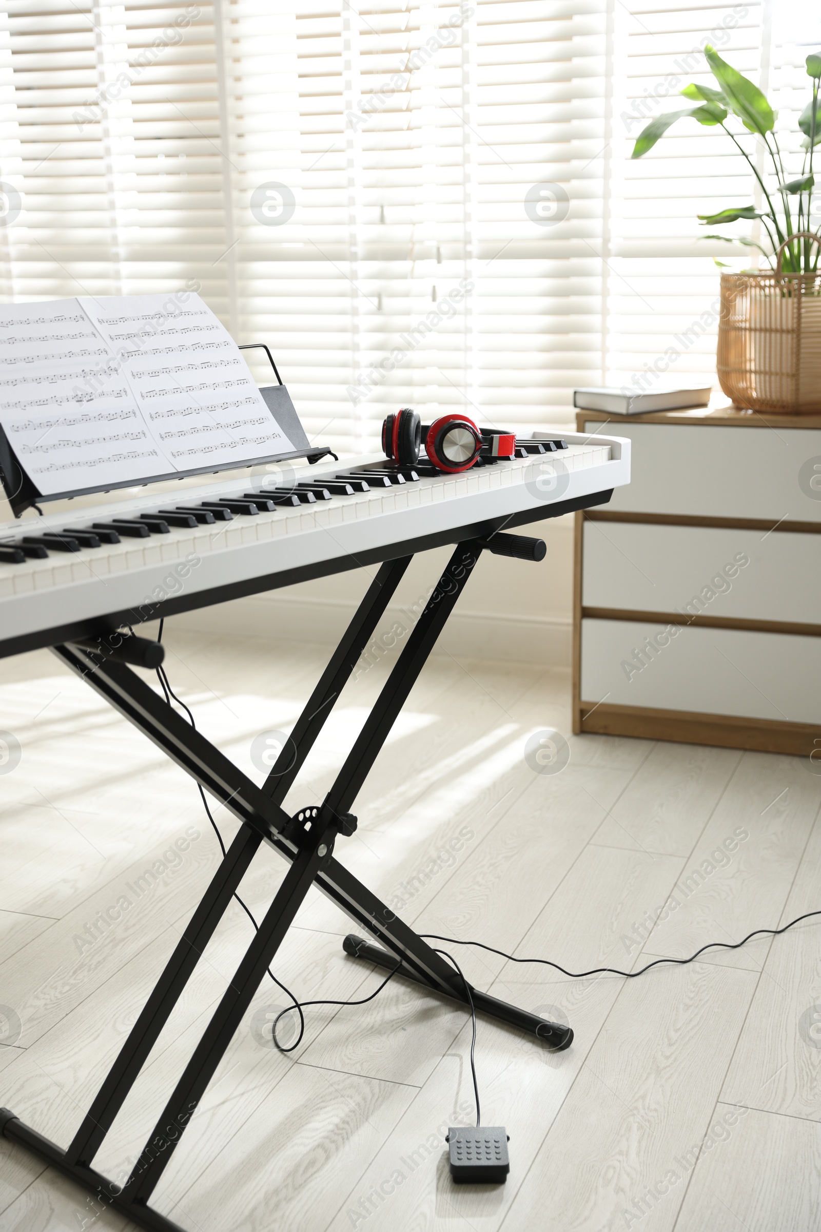 Photo of Synthesizer with music sheets and headphones indoors