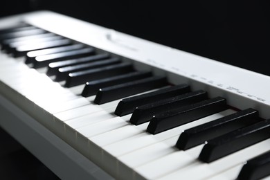 Photo of Synthesizer on black background, closeup. Electronic musical instrument